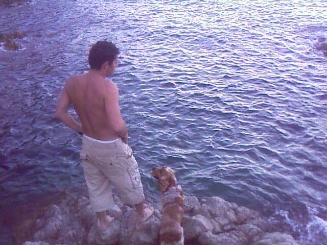 Hombre y perro mirando playa de la costa brava