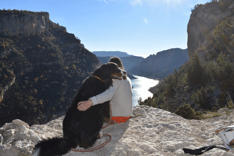 Chica con su perro con las vistas de fondo del congost